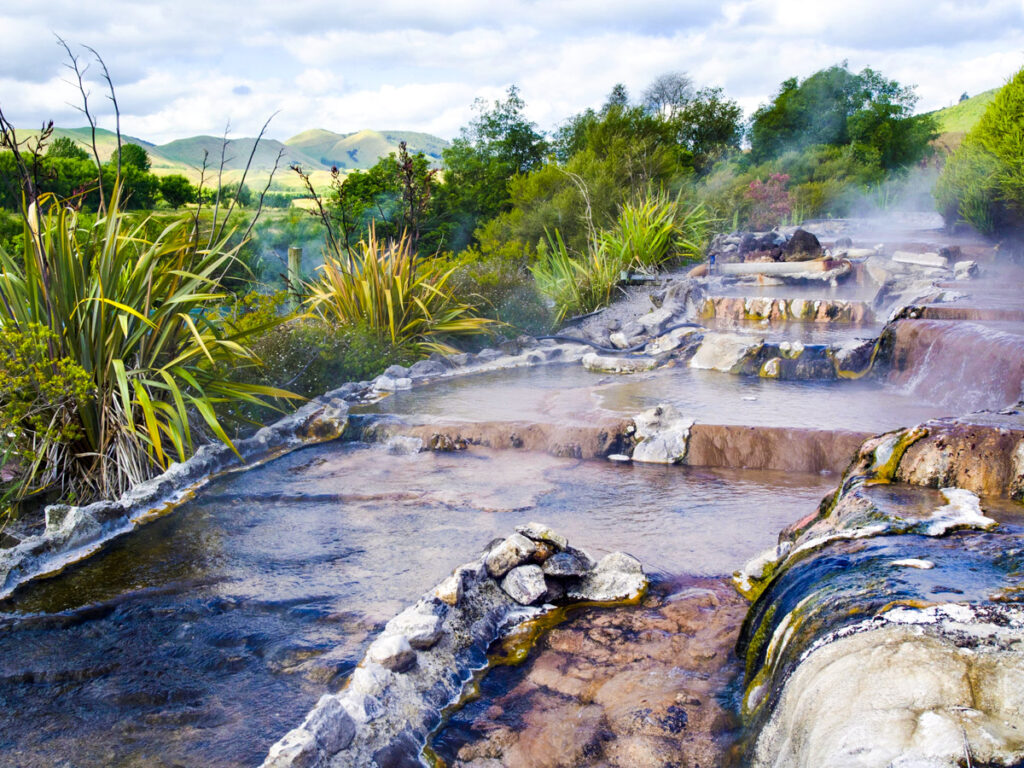 small thermal pools on cliffside with views of rotorua