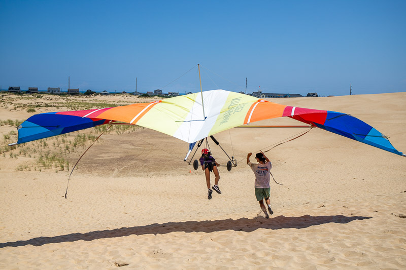 people kite flying on sand dunes