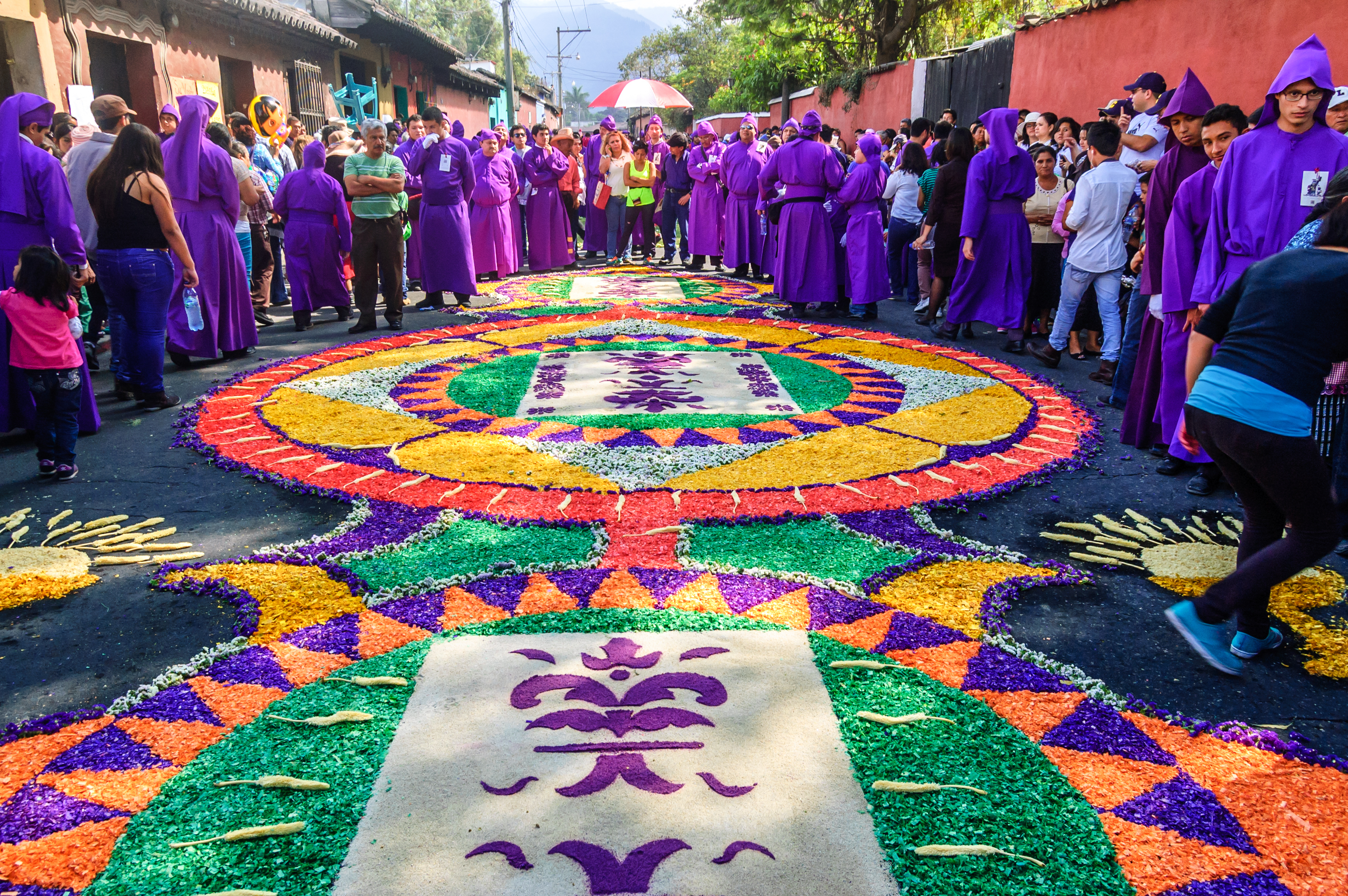 Onlookers & float bearers admire dyed sawdust patterns in the streets of Antigua, Guatemala, during Semana Santa.