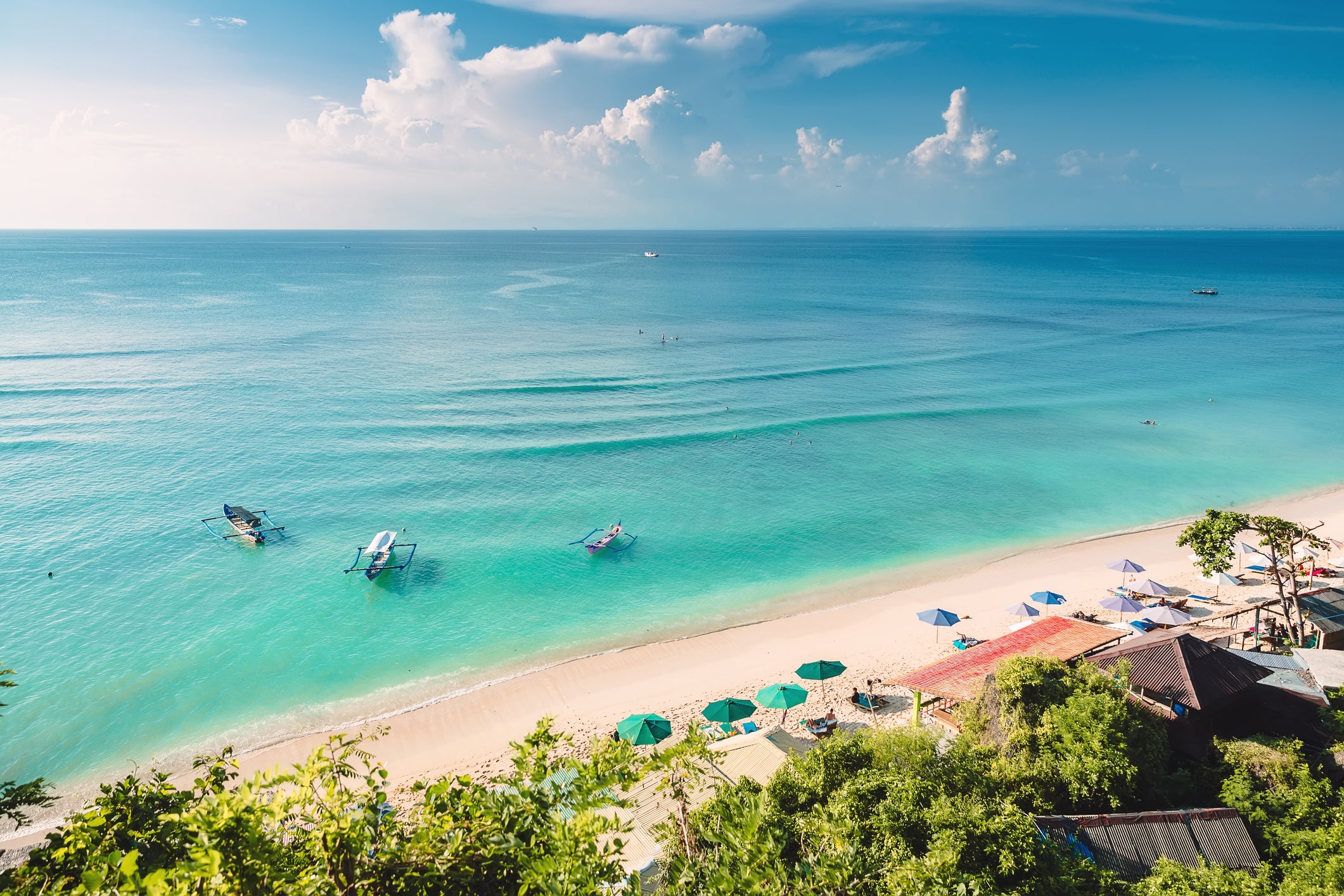 Tropical blue ocean, sandy beach and boats in Indonesia, Bali