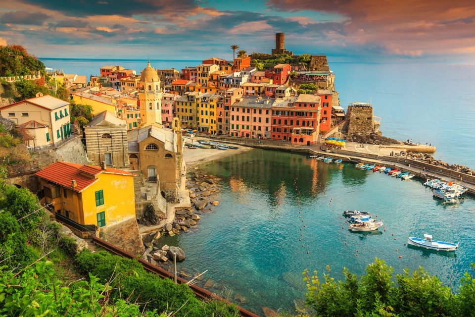 Stunning panorama of Vernazza, spectacular colorful medieval buildings and fishing boats in harbor, Cinque Terre National Park, Liguria, Italy