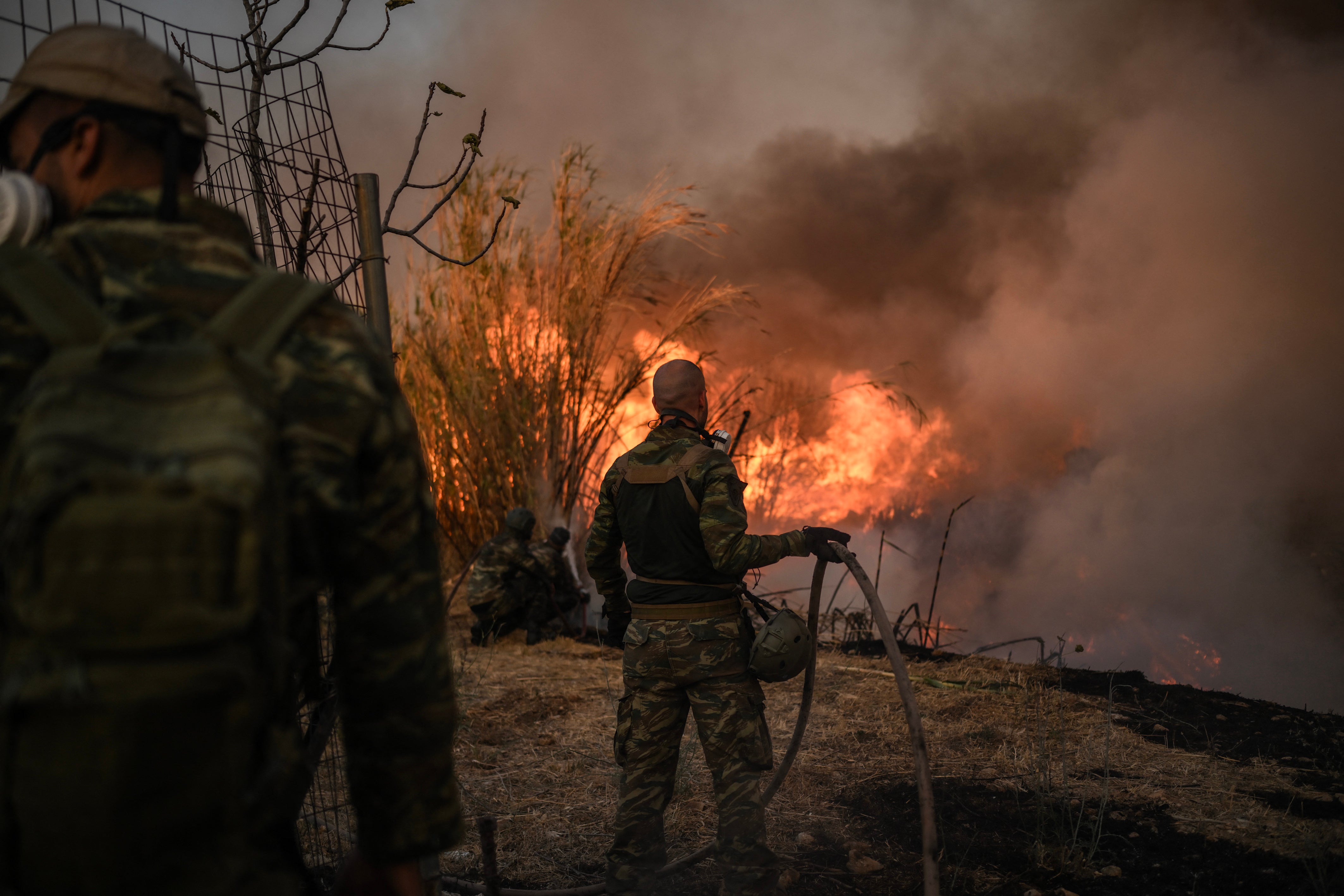 Volunteers fight a wildfire near Penteli, not far from Athens