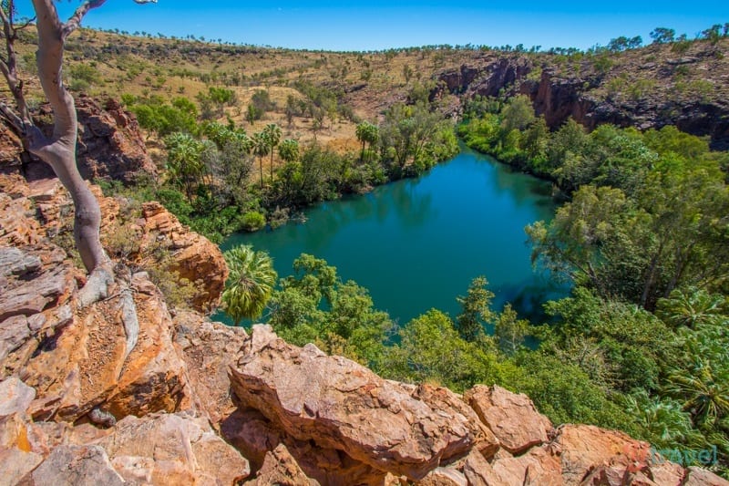 tall rock piles and trees around a lake