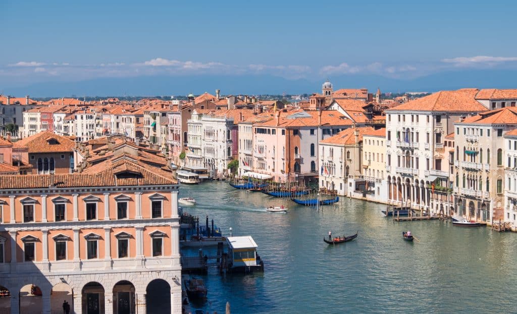 A view from above of the Grand Canal in Venice, surrounded by houses with orange roofs.