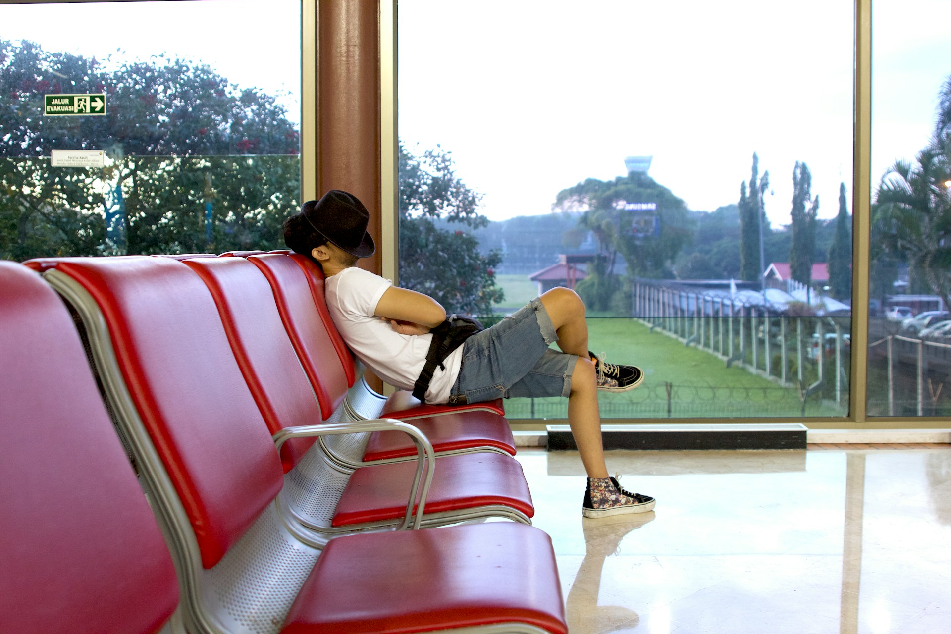 A traveler catching some sleep at an airport, possibly due to jet lag (photo: Ray Sangga Kusuma).