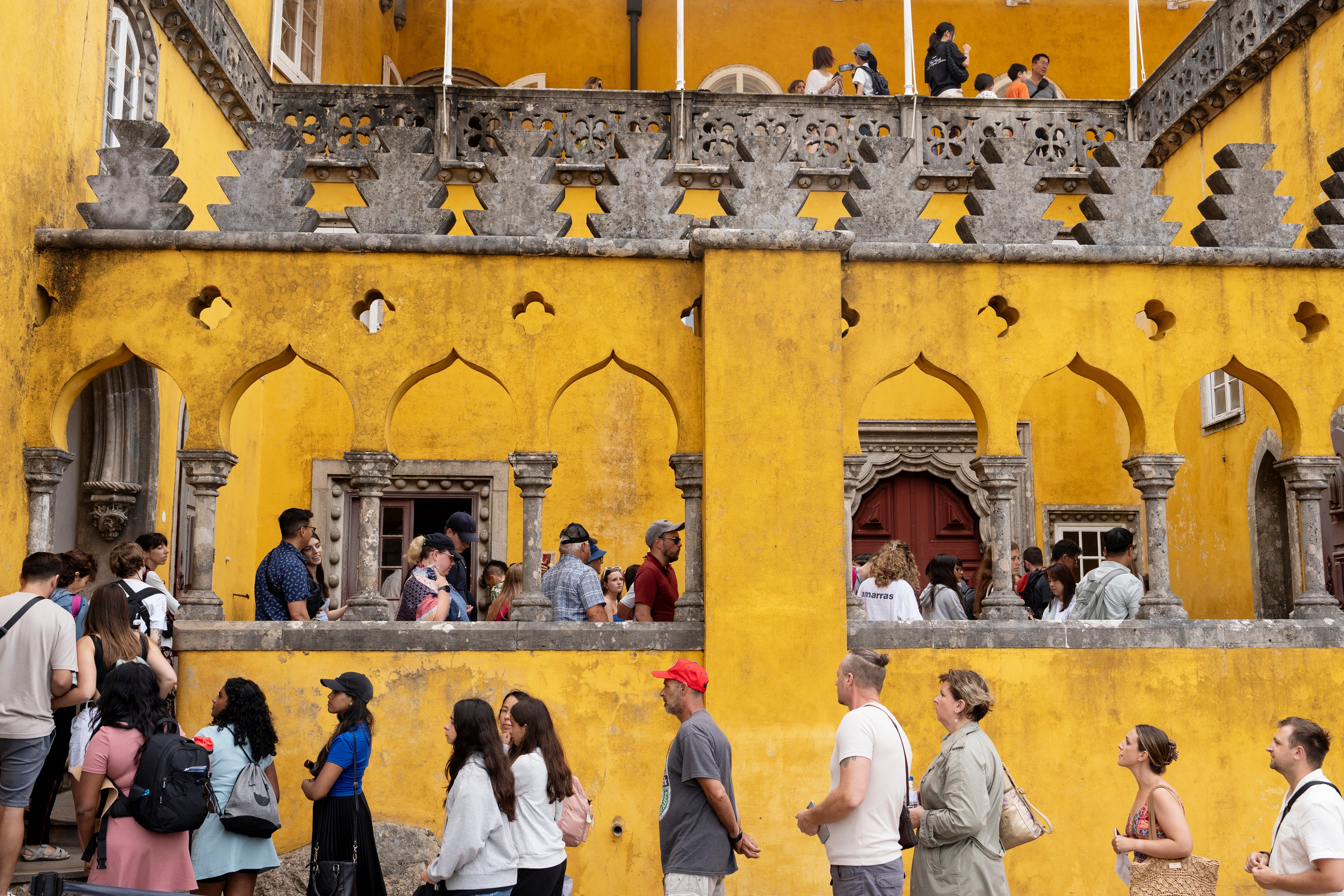 Tourists queue to visit the interior of the 19th century Pena Palace in Sintra, Portugal