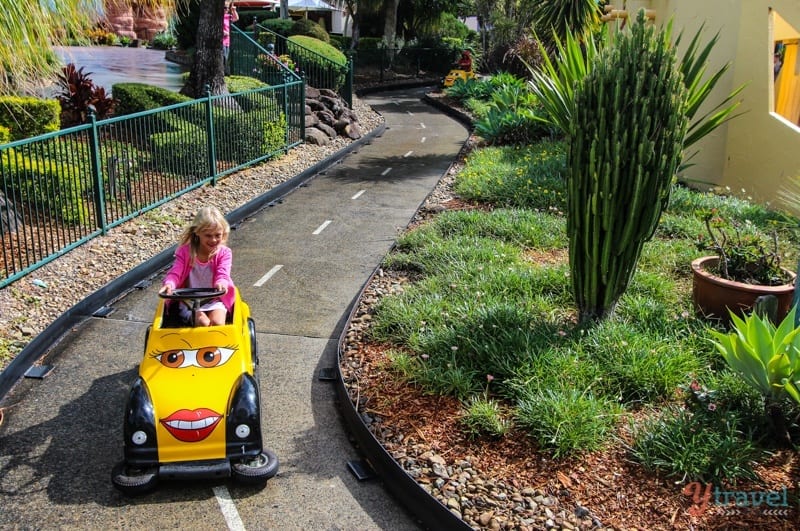 girl riding on a car ride in a theme park