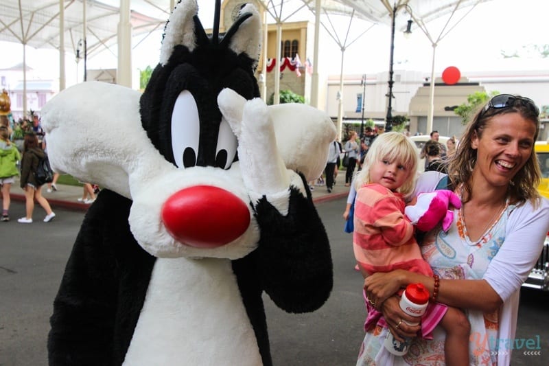 a kid next to Syvester the cat in costume