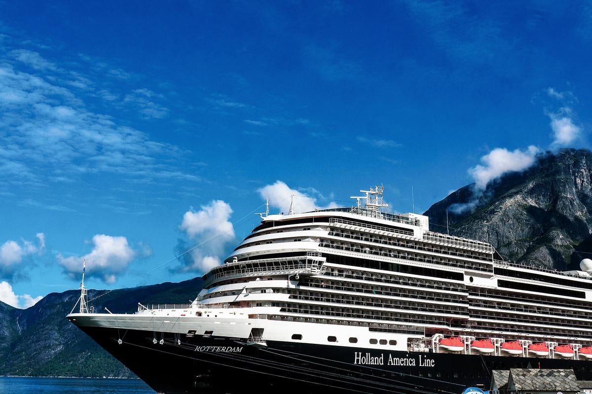 Holland America Line cruise ship in Eidfjord, Norway with fjords and mountains backdrop