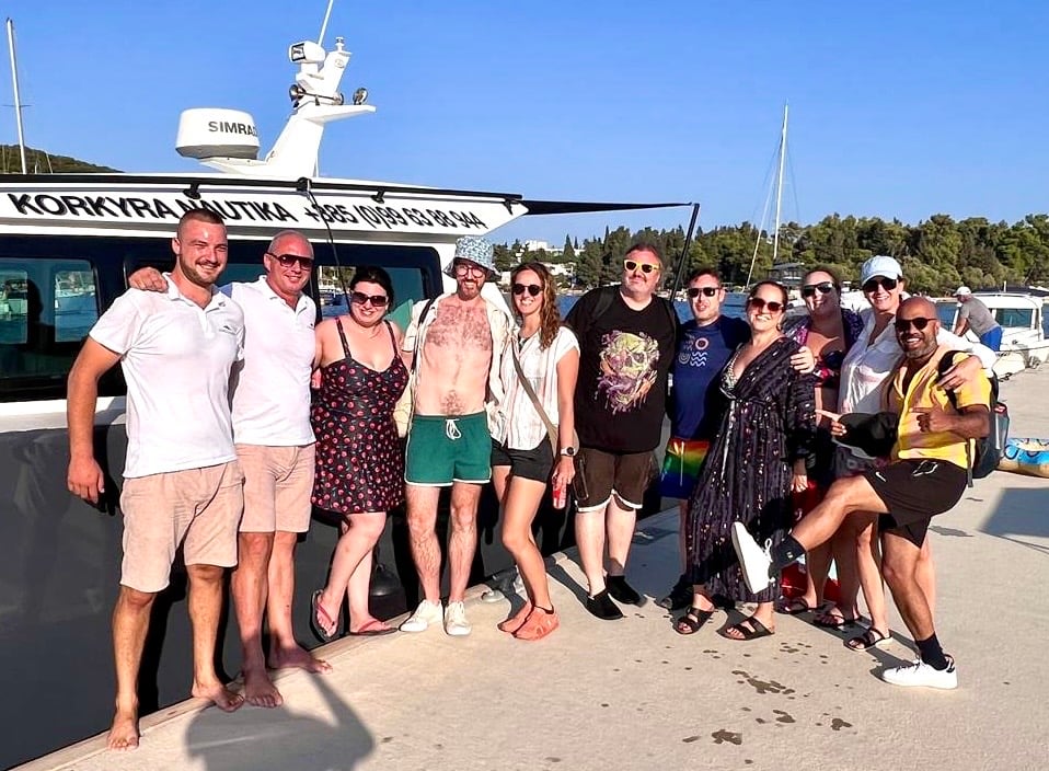 Kate and a big group of friends standing on a dock and smiling.