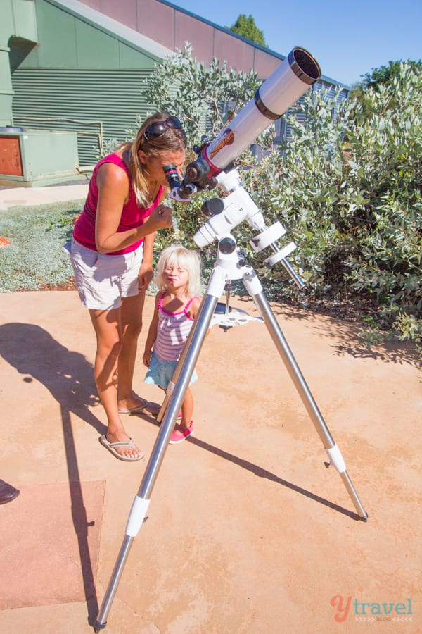 woman looking through a telescope