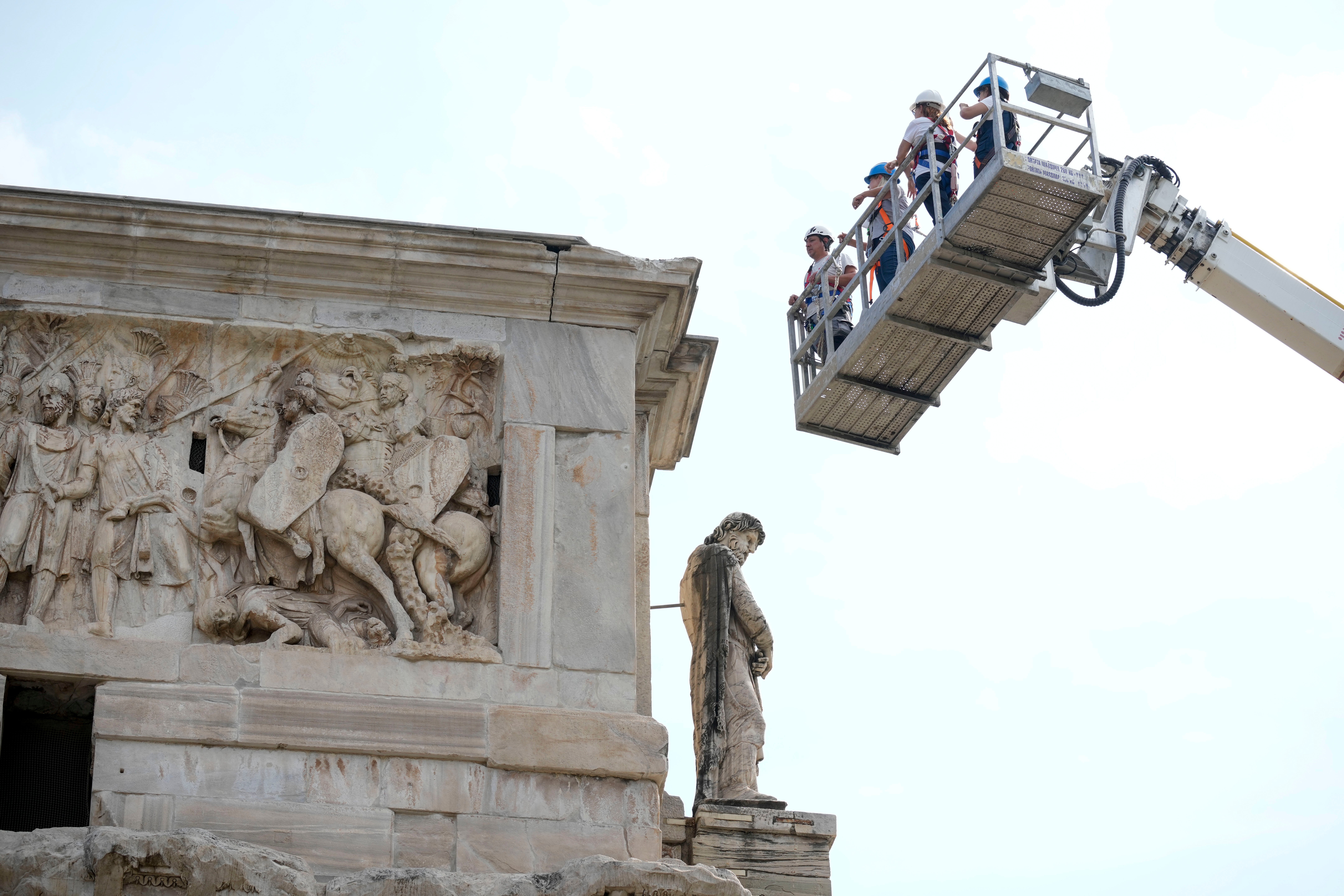 Workers inspect the 315 A.D Arch of Constantine, near the Colosseum, in Rome, Wednesday, Sept. 4, 2024, after lightning struck it during a storm