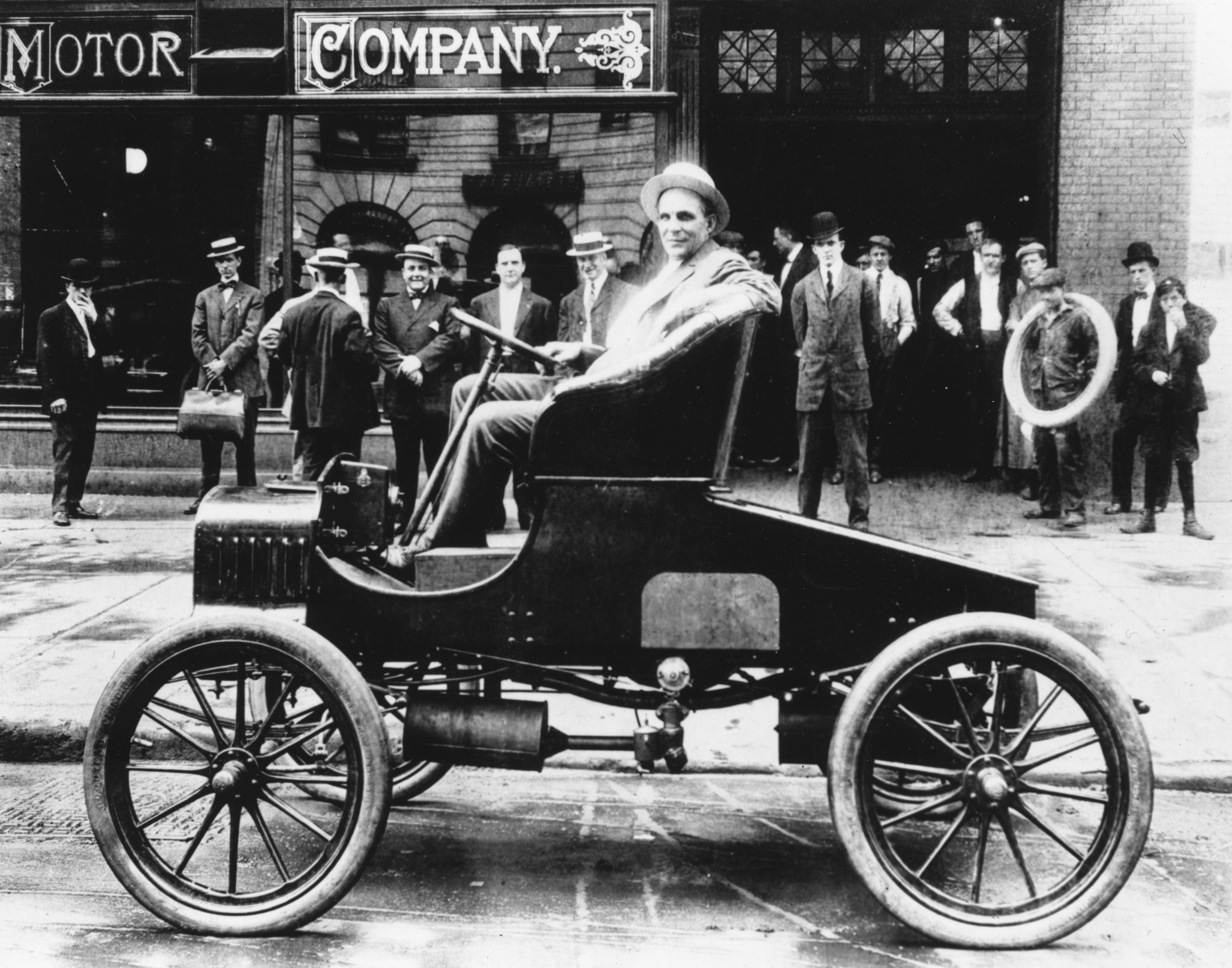 Henry Ford poses with one of his vehicles