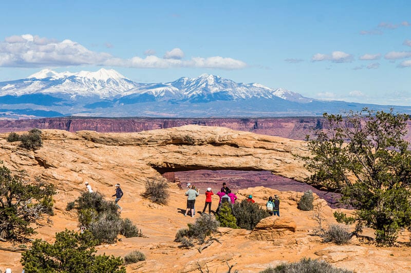 Mesa ARch with snow capped mountains in the background