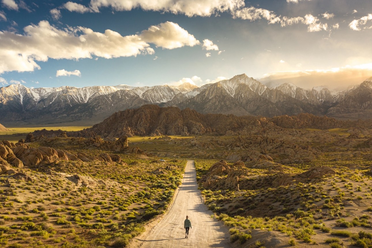 Lonely person walking on a pathway in Alabama hills in California with Mount Whitney in background