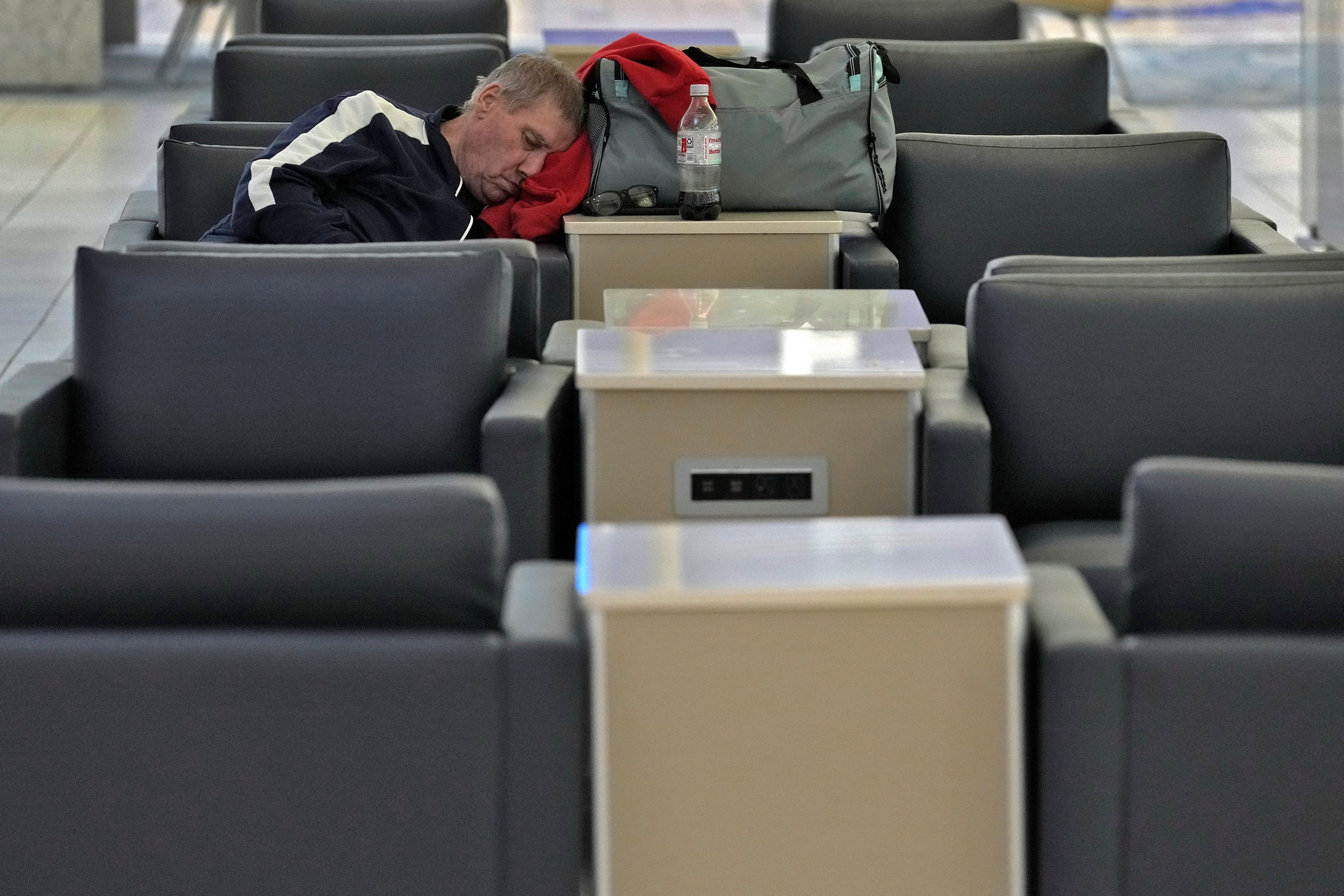 A passenger sleeps at the Tampa International Airport Tuesday