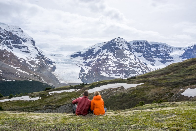 people sitting on mountain looking at view of Athabasca Glacier