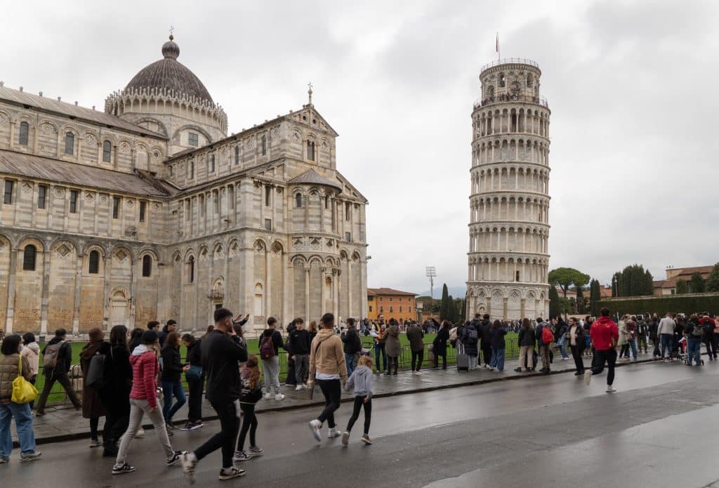 Big crowds of people posing in front of the Leaning Tower of Pisa