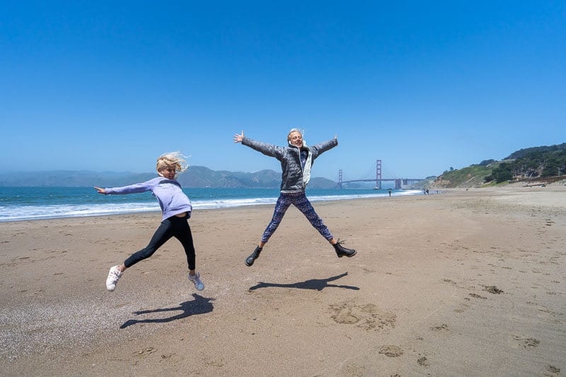 girls jumping in the air on the beach