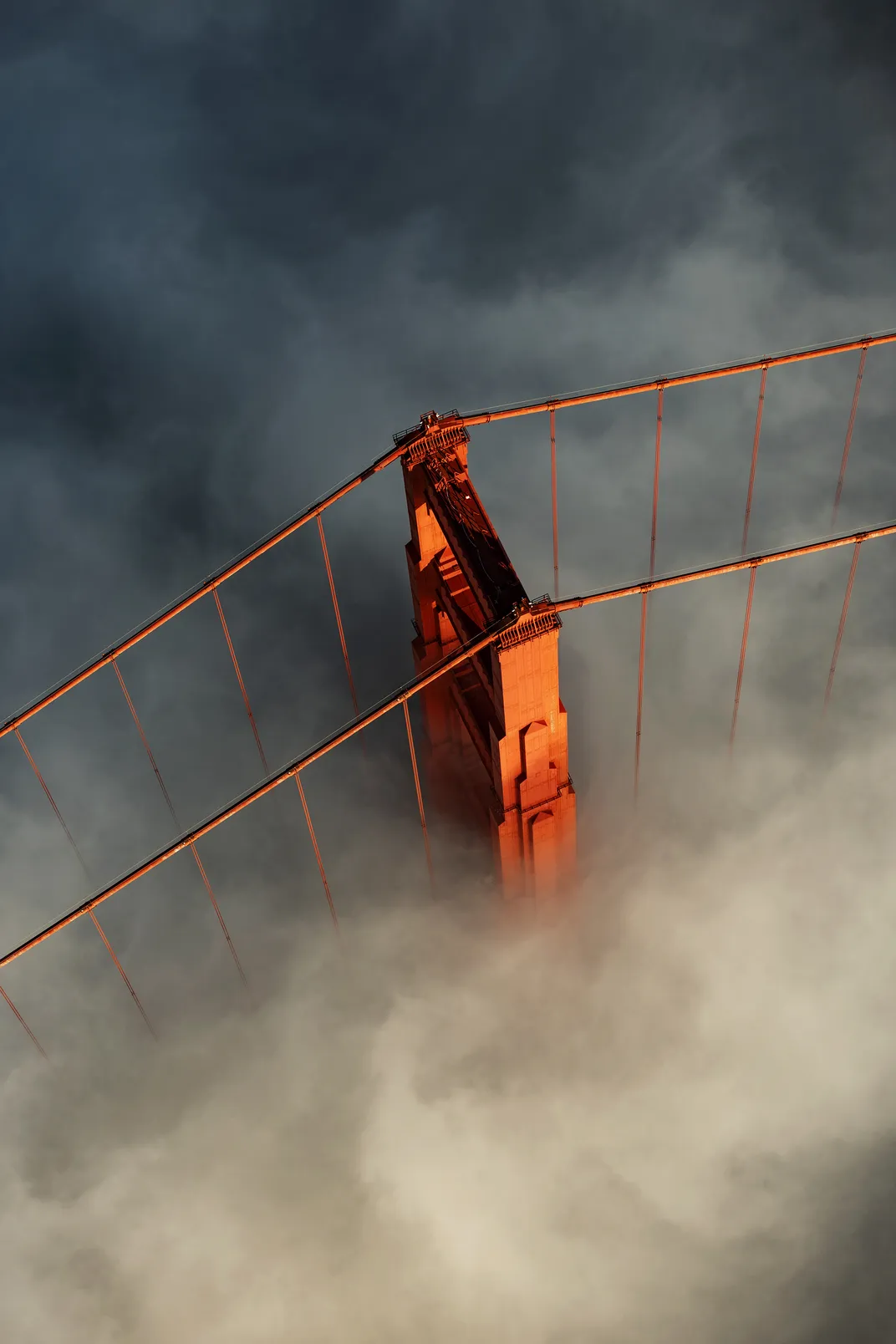 An aerial view of the Golden Gate Bridge over clouds