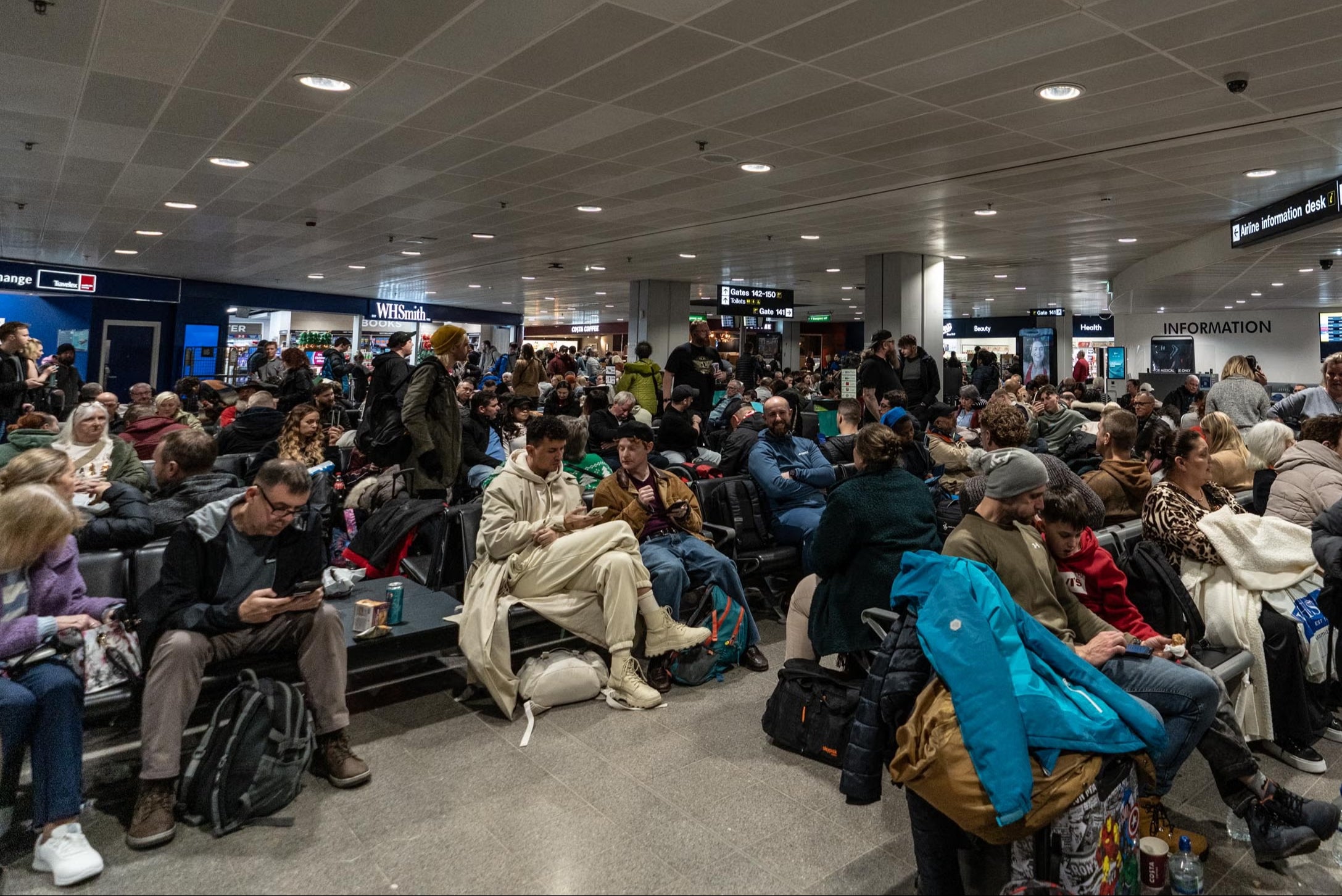 Passengers in Manchester Airport waiting for their flights in Terminal 3