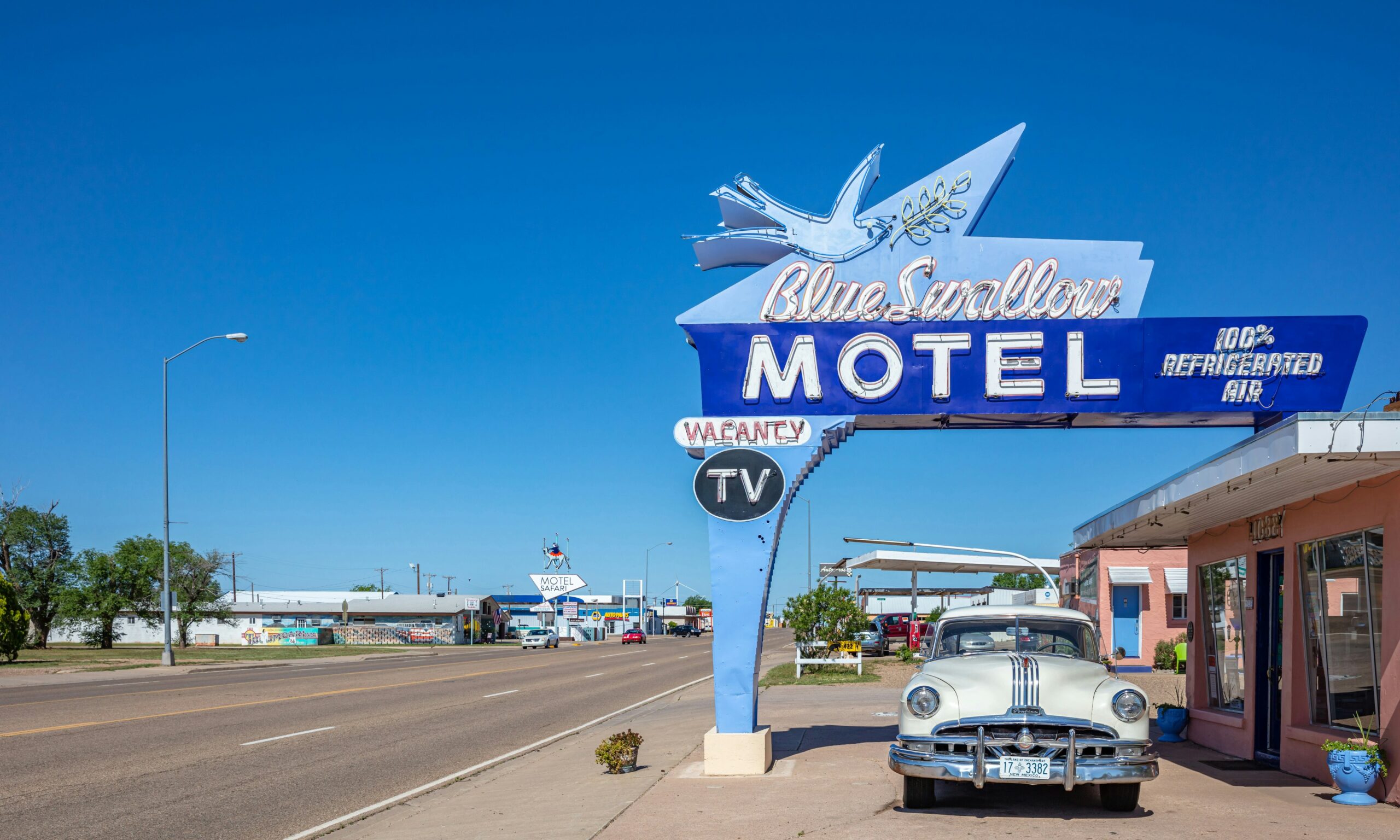 Tucumcari, New Mexico, USA. Motel Blue Swallow next to mother road, route 66, a sunny day. An antique pontiac car is parked at the entrance.