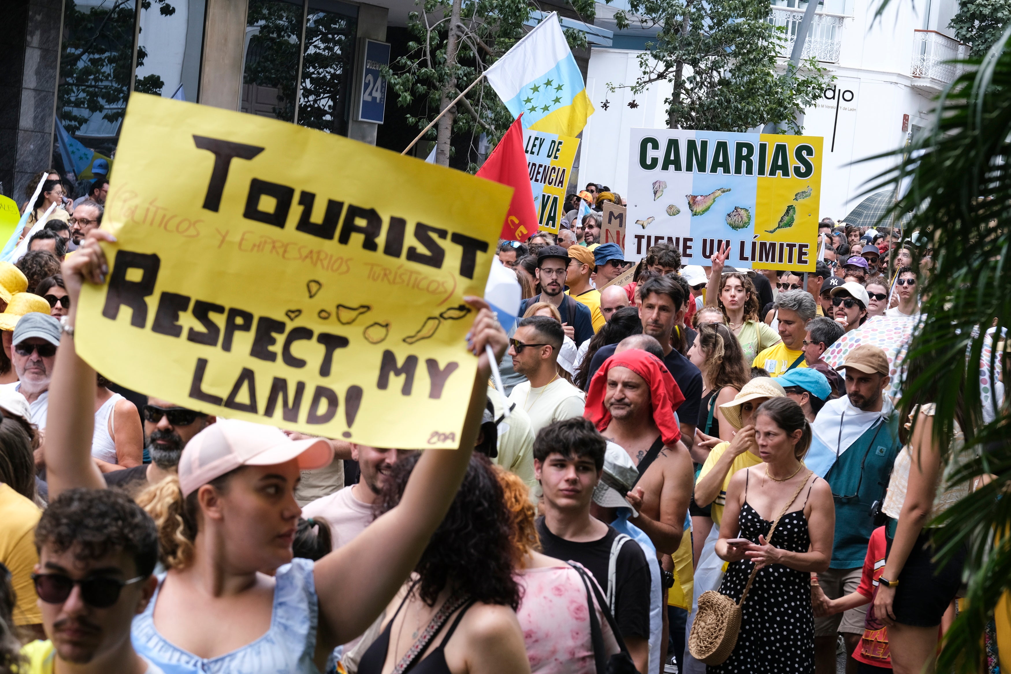 People display placards during a demonstration for a change in the tourism model in the Canary Islands