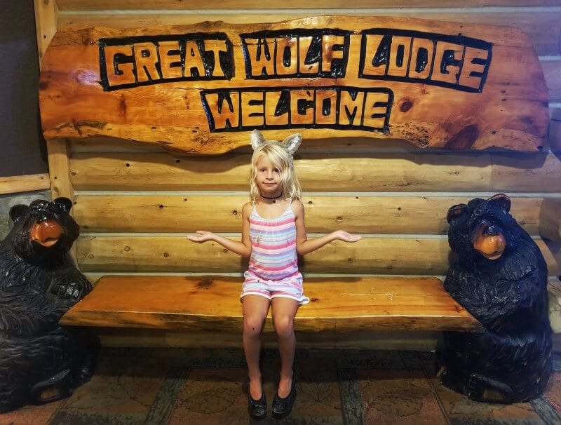 girl posing at great wolf lodge sign with wolf ears on