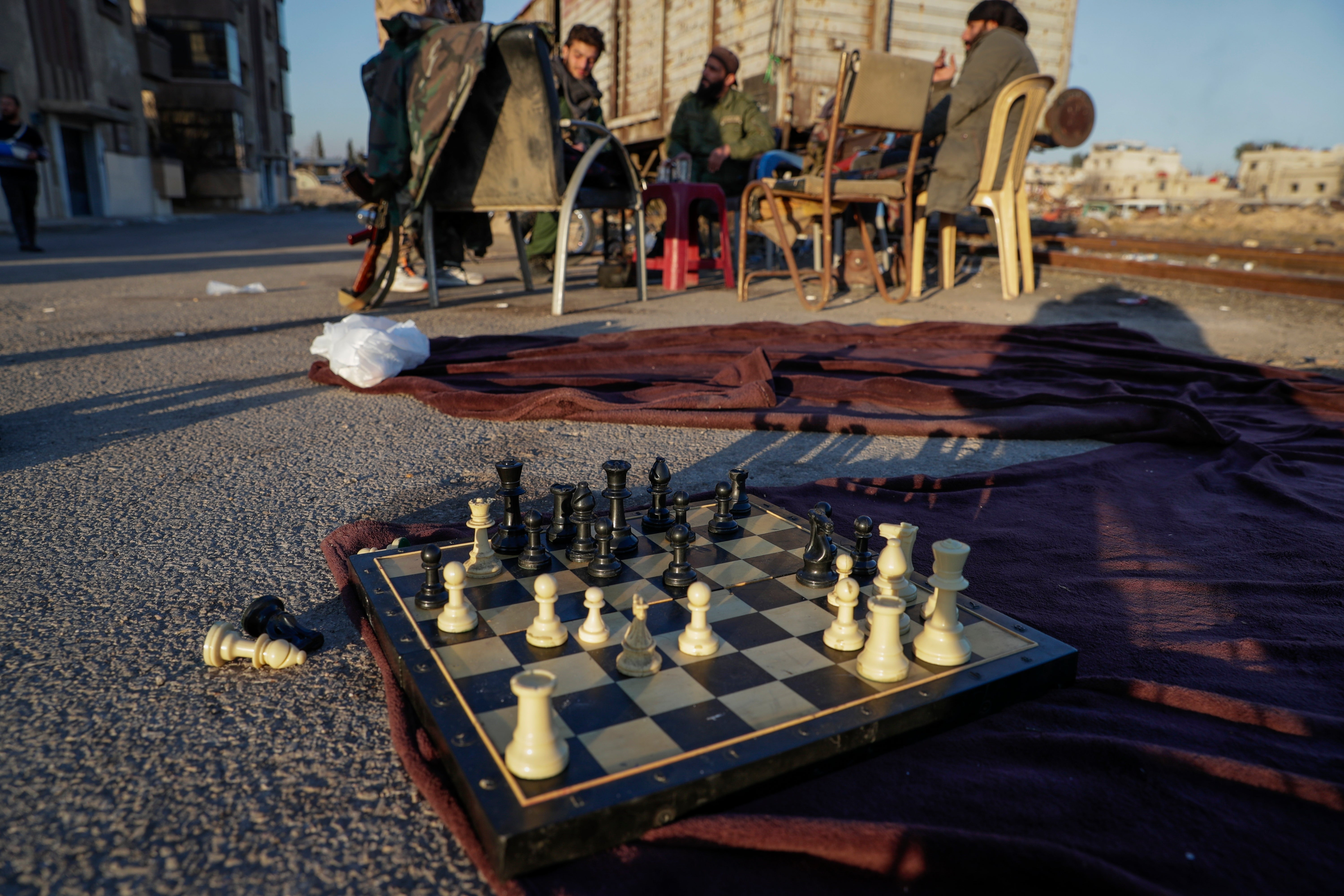 A chess board next to members of the new Syrian security force is seen at the Qadam train station in Damascus, Syria, Monday, Jan. 13, 2025. (AP Photo/Omar Sanadiki)