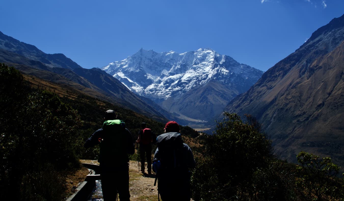 Three travelers hiking the Salkantay trek in Peru on a guided tour