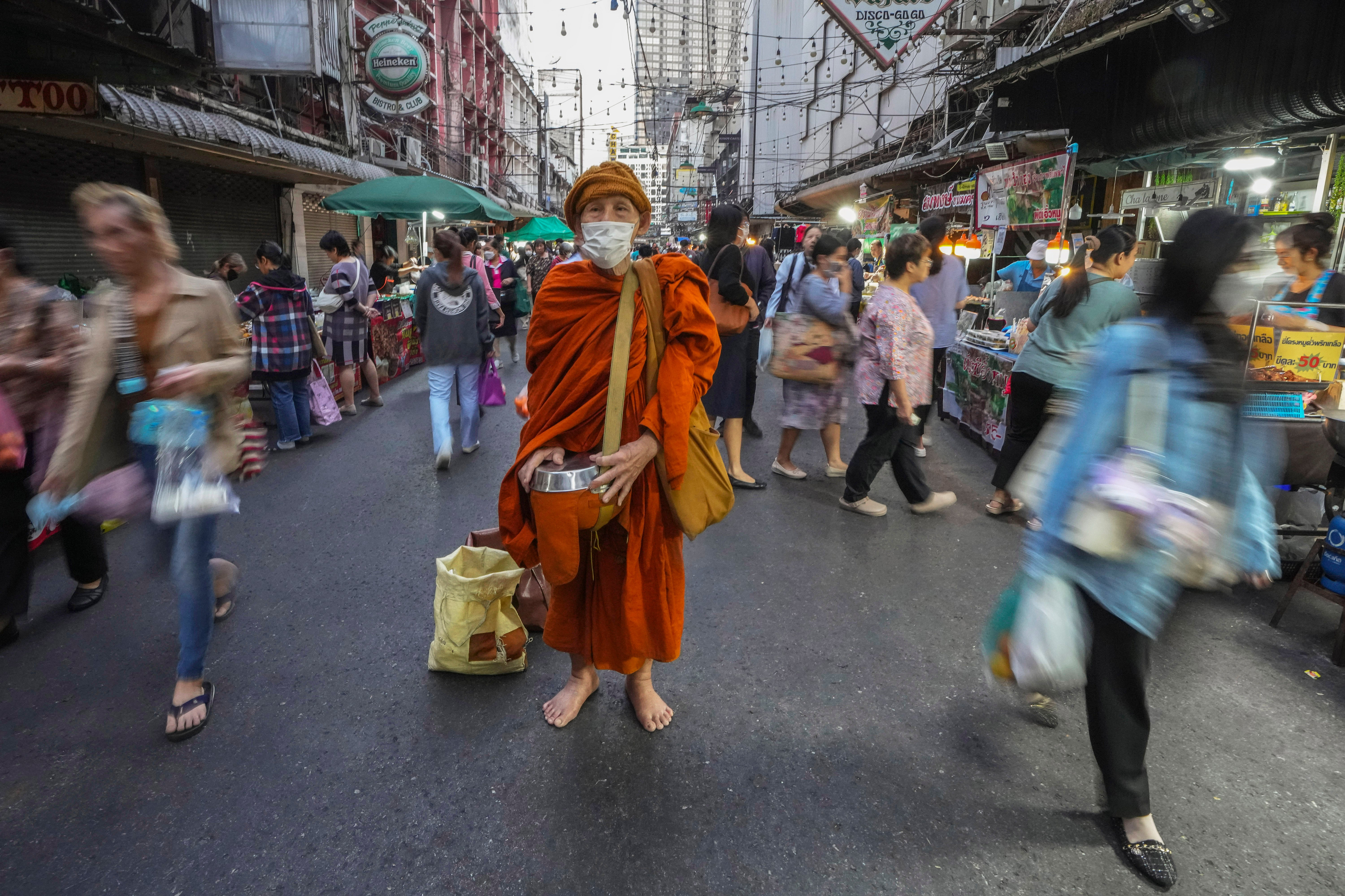 A Buddhist monk wears a hat for warmth in Bangkok