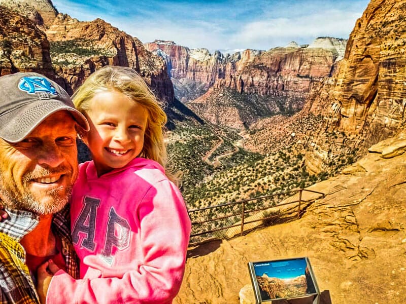 dad and child posing at zion national park with view