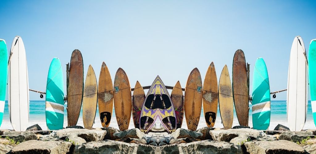 Mirror image of standing surf boards of varying size 