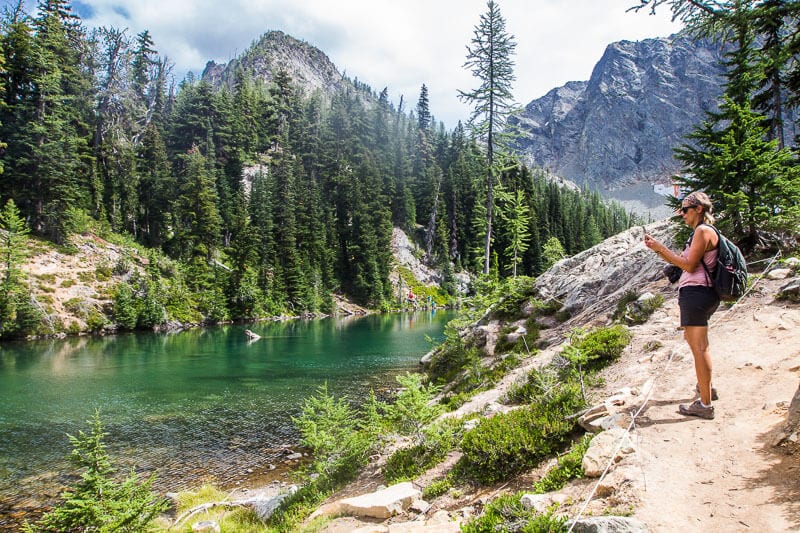 woman taking photo of glacial river at North Cascades National Park, Washington State