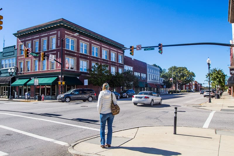 woman on street corner looking at buildings on main street Smithfield,