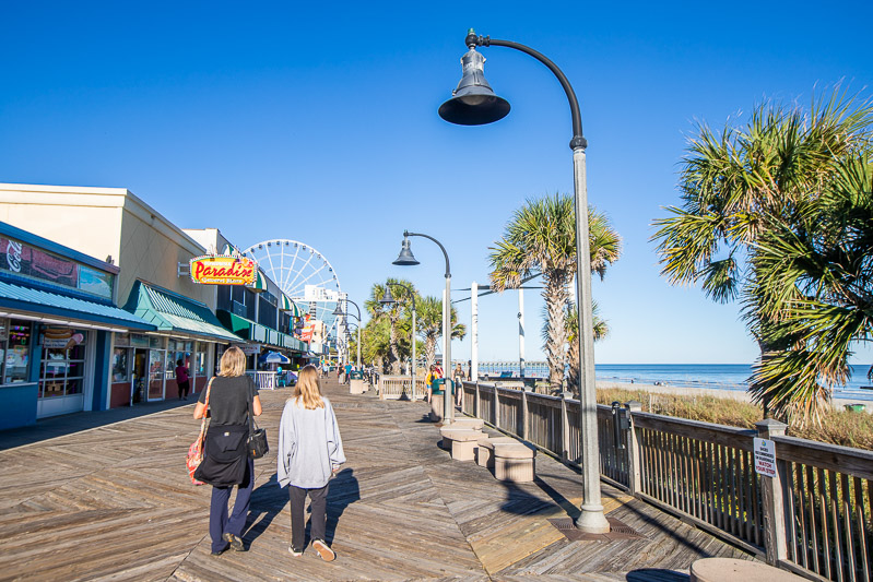 woman and child walking along boardwalk at myrtle beach