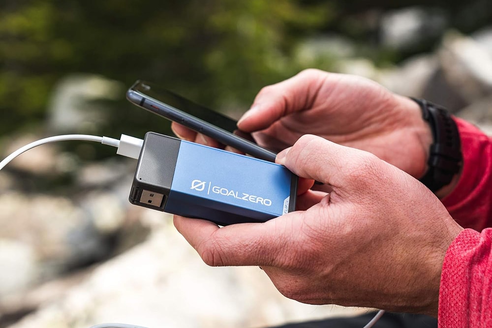 A man uses a compact power bank for camping