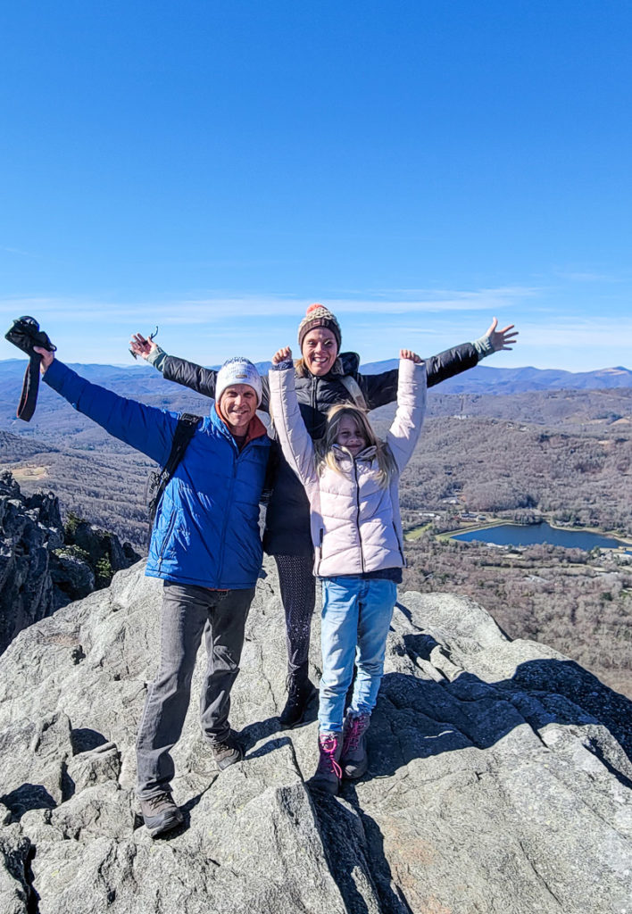 people standing on a rock with their arms in the air