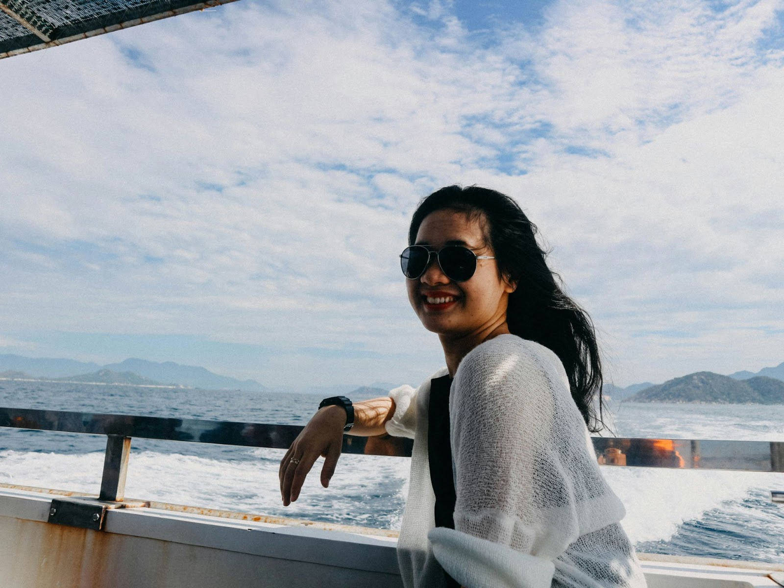 Woman with glasses posing in a boat at sea