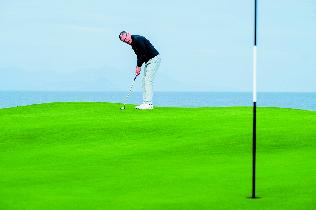Steve North reading a long putt on the 10th green at Trump Turnberry