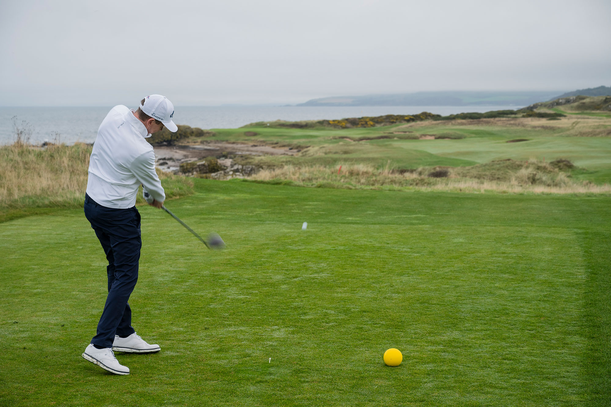 Ben Emerson just past impact position hitting a driver off the tee at Trump Turnberry