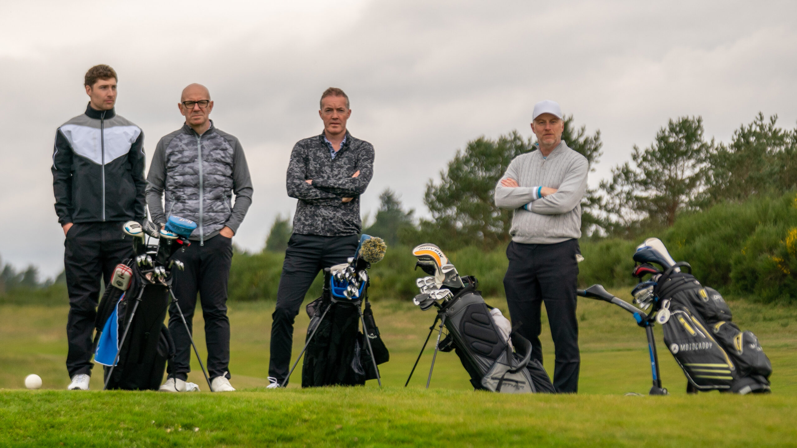 four golfers waiting on a tee because of slow play