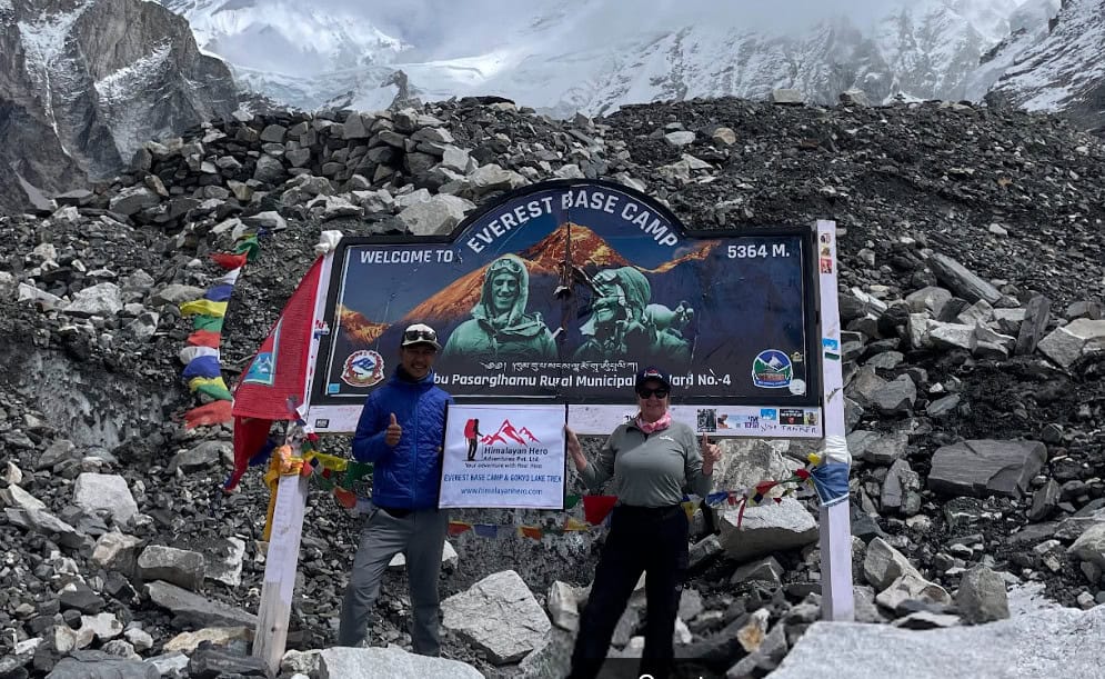 Trekkers in front of the Everest Base Camp sign in Nepal.