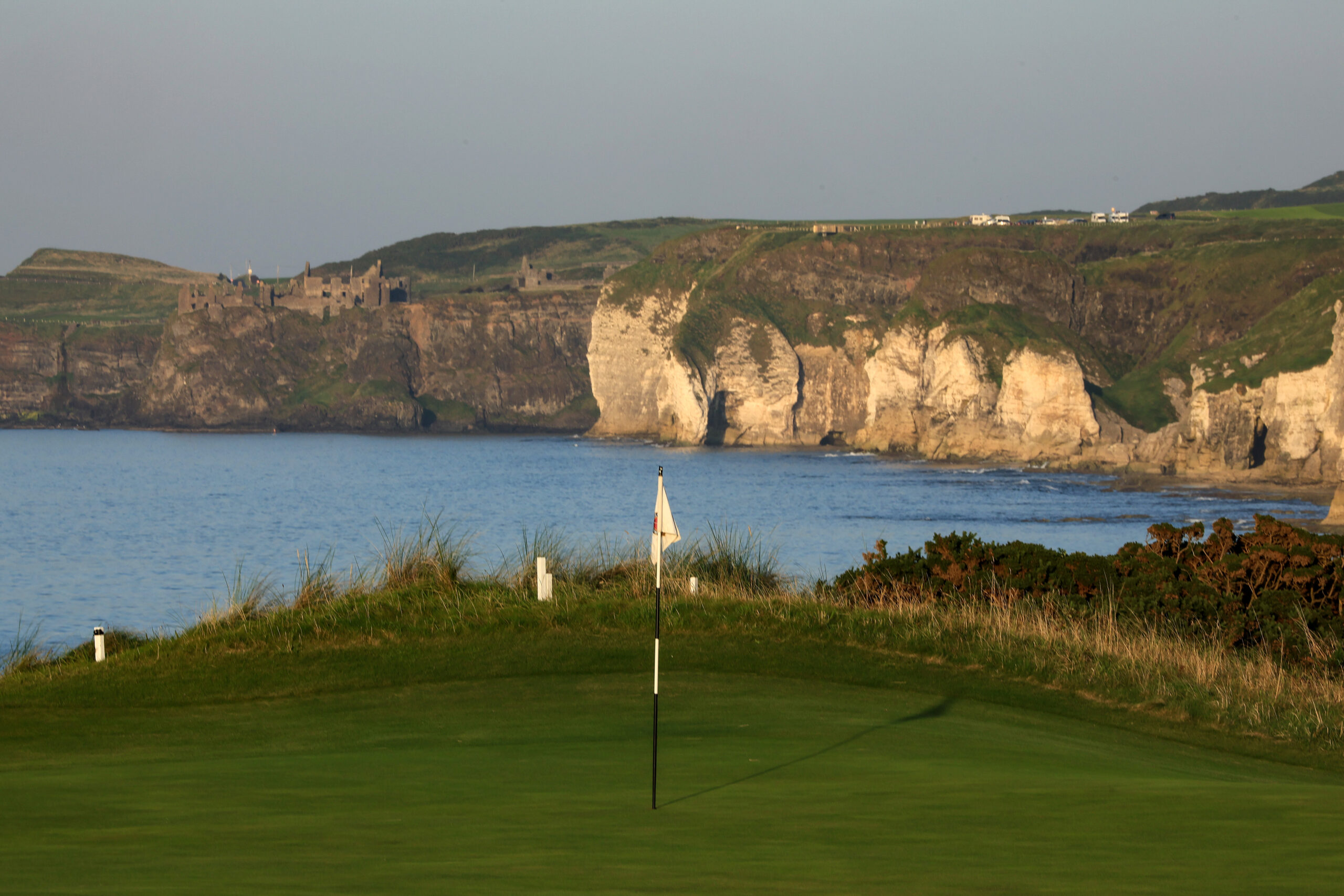 Royal Portrush in the foreground with Dunluce Castle in the background on top of the cliffs
