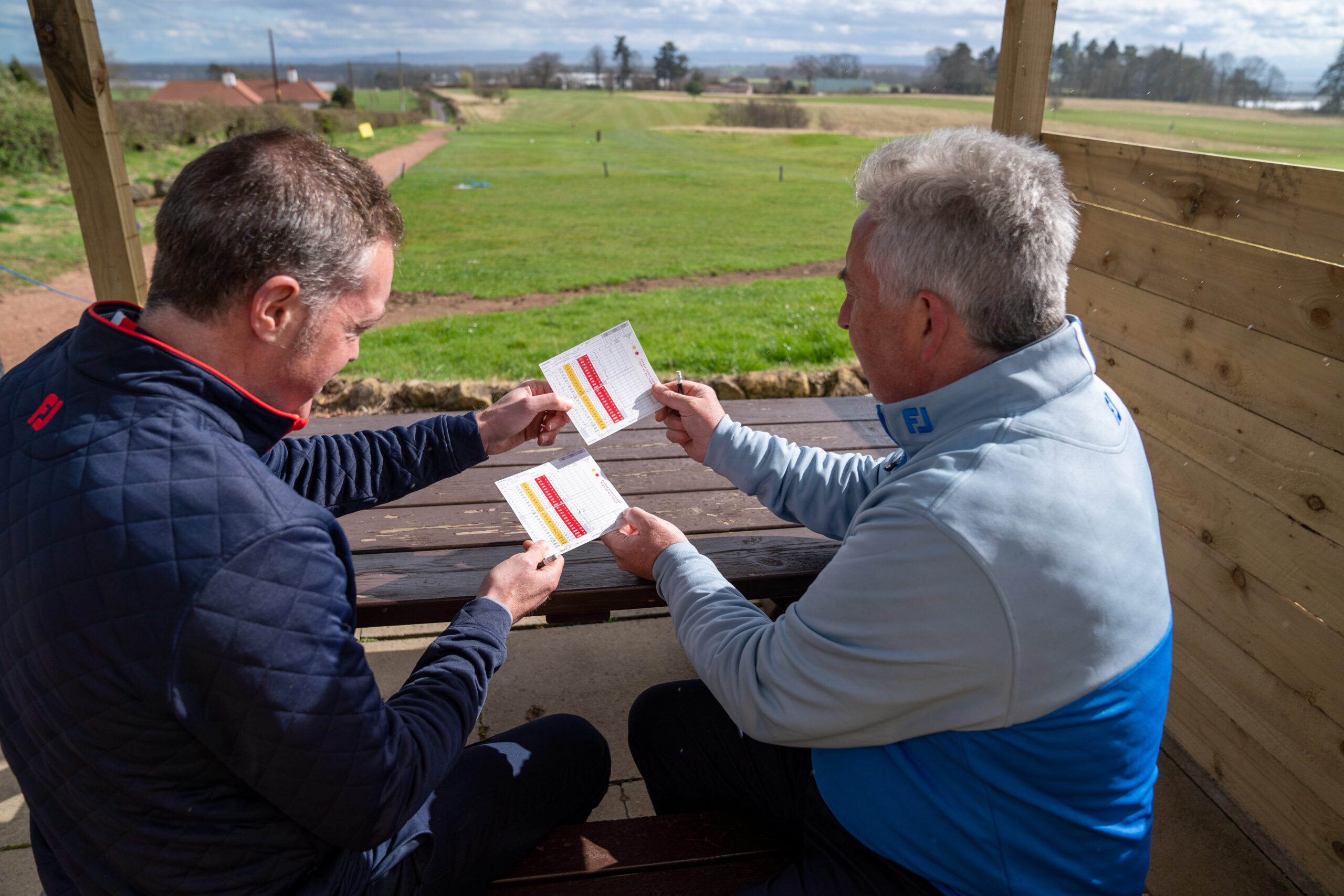 Players exchanging golf scorecards