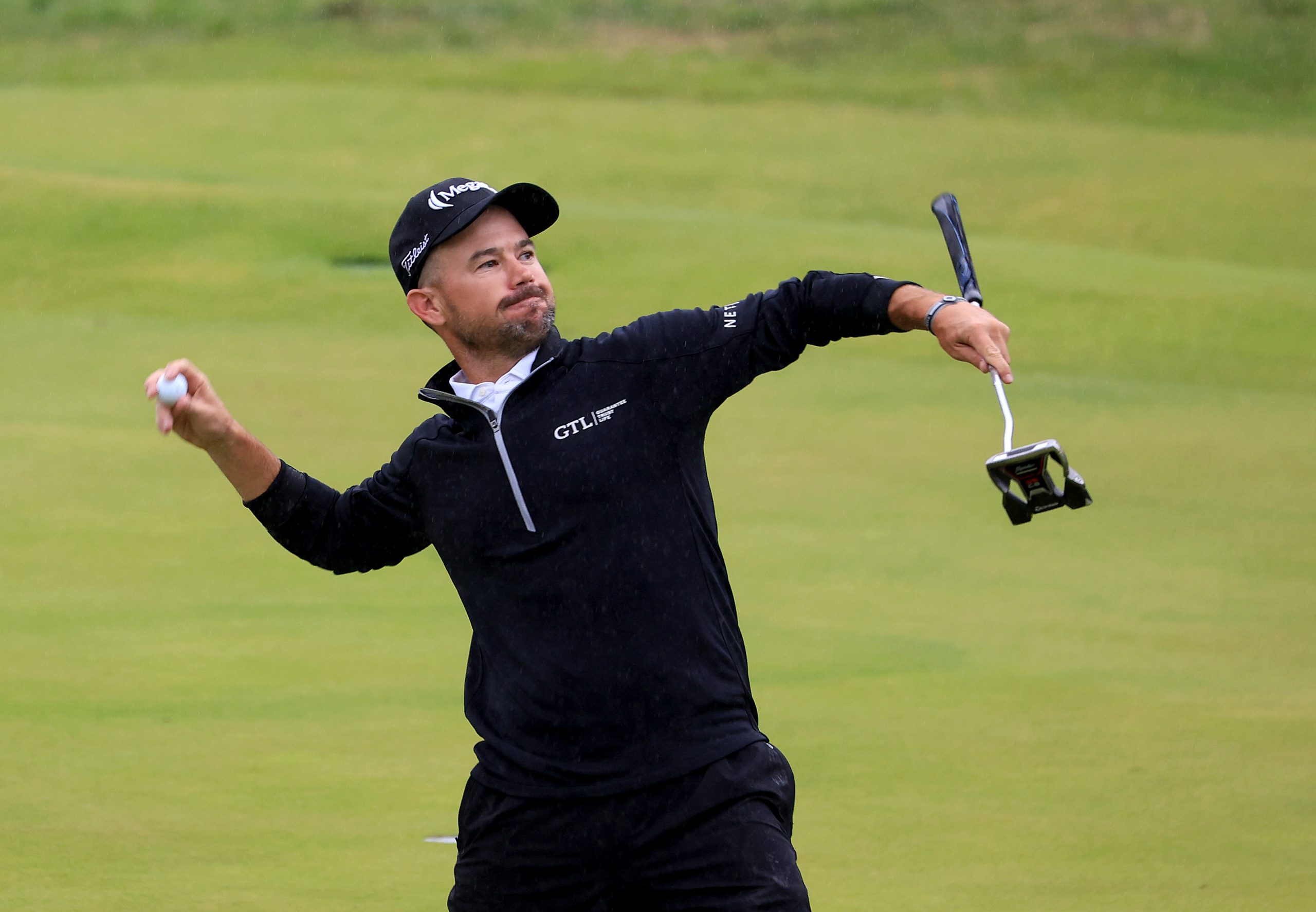 Brian Harman throws a golf ball into the crowd