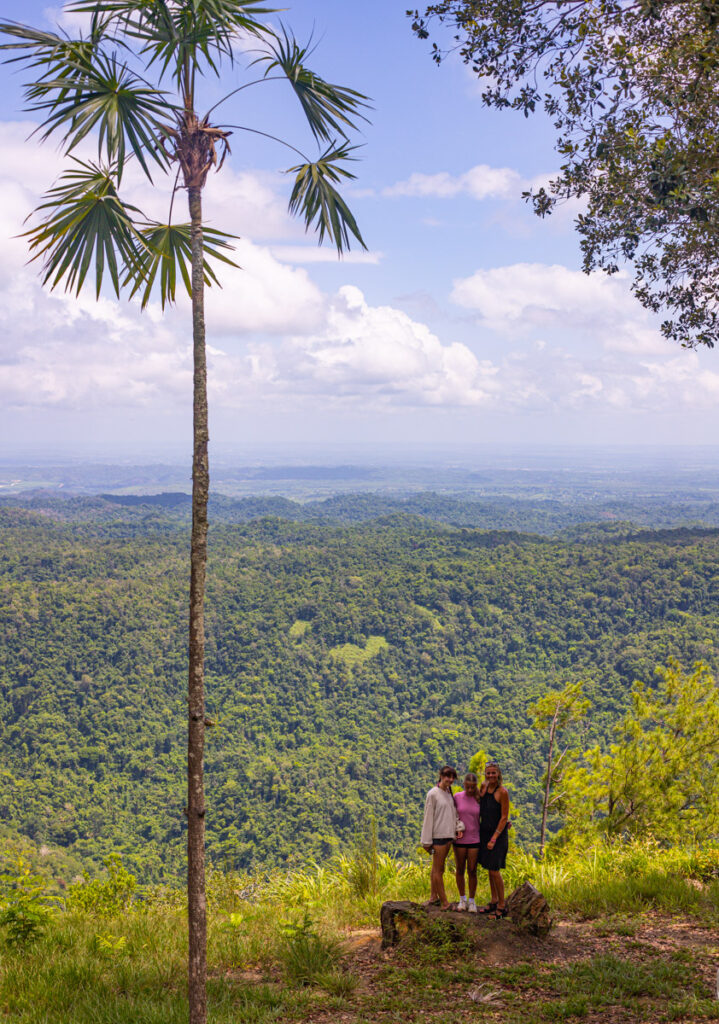 family posing in front of view at mountain pine ridge reserve