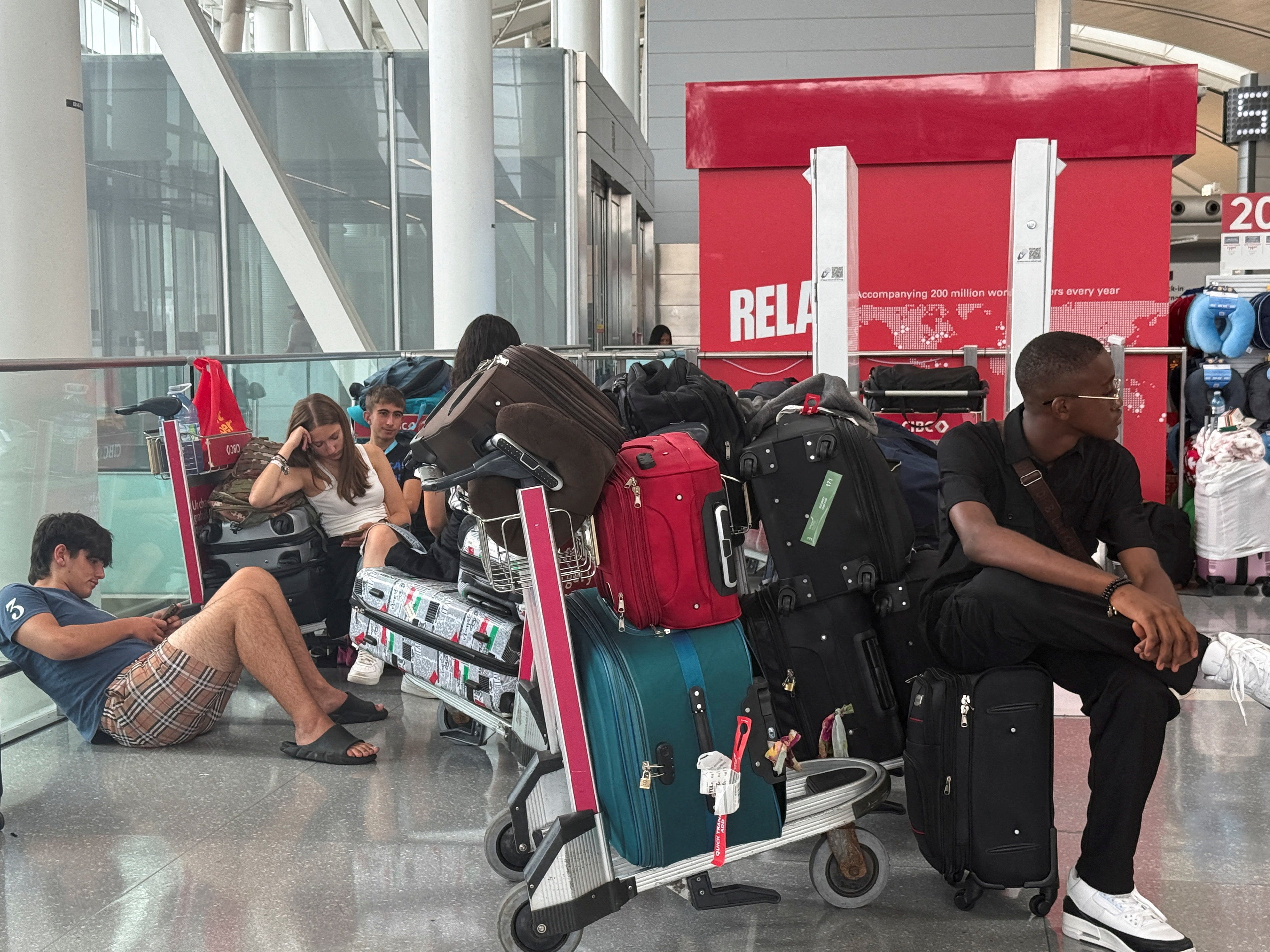 People sit with their luggage at Toronto Pearson International Airport amid the strike