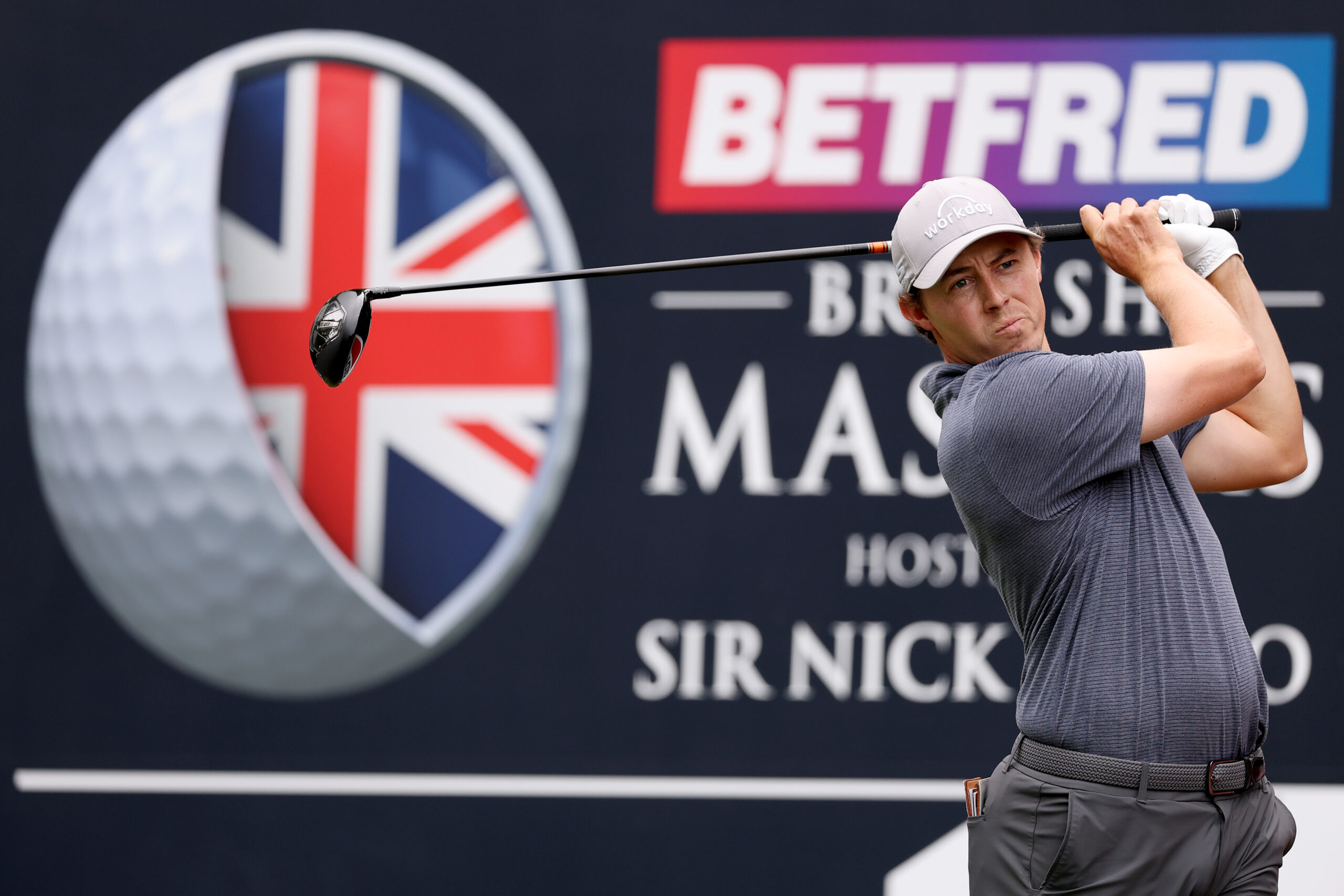 Matt Fitzpatrick hits a driver in front of a British Masters board