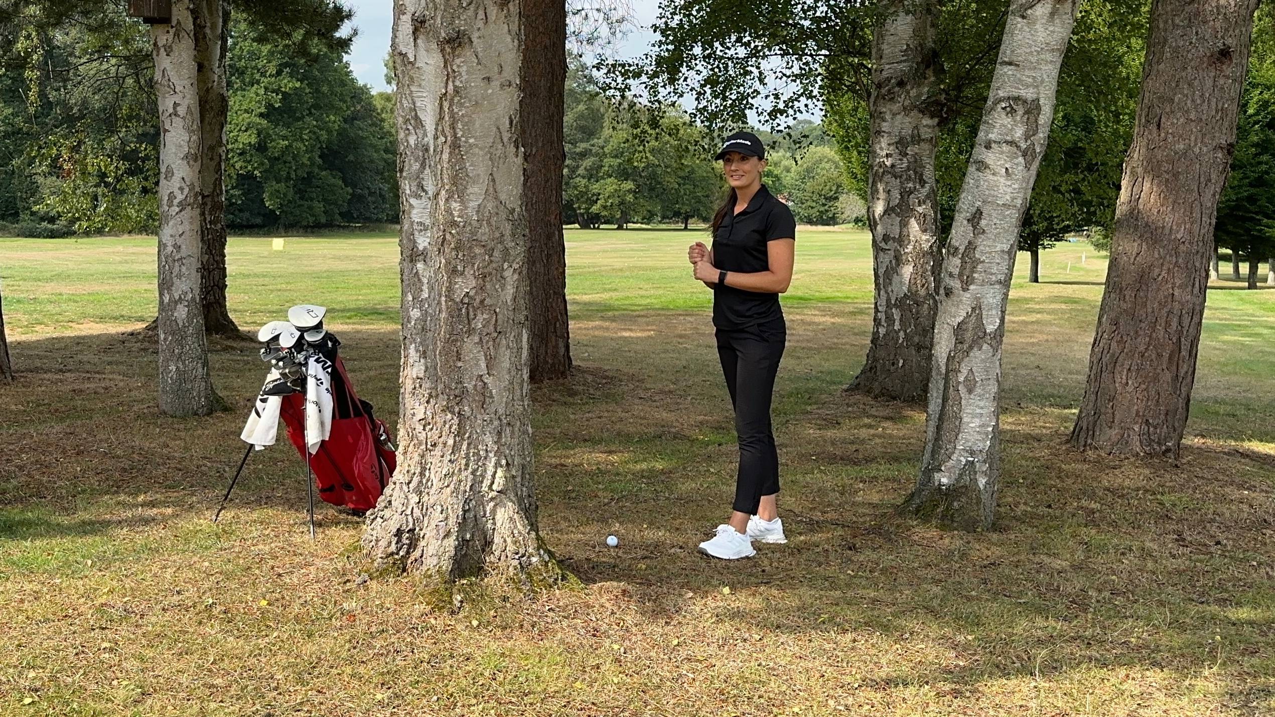 Jess Ratcliffe with her ball behind a tree